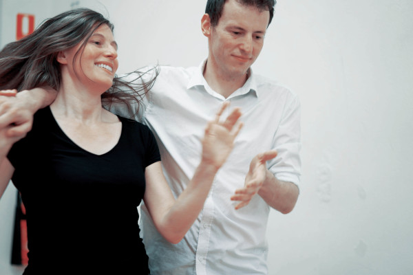 Two people dancing, one happy and one concentrating